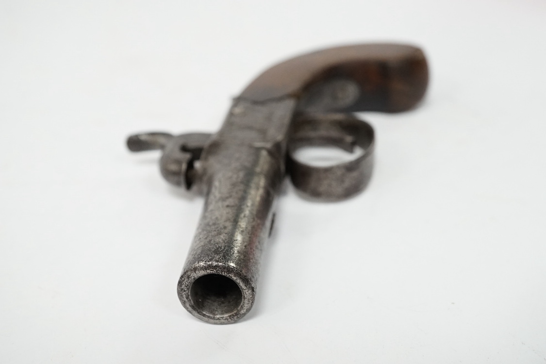 A boxlock percussion pocket pistol, Birmingham proved, frame engraved with flag trophies and signed Cook, London within ovals, sliding top thumb safety, partly chequered walnut grip with vacant silver escutcheon. Conditi